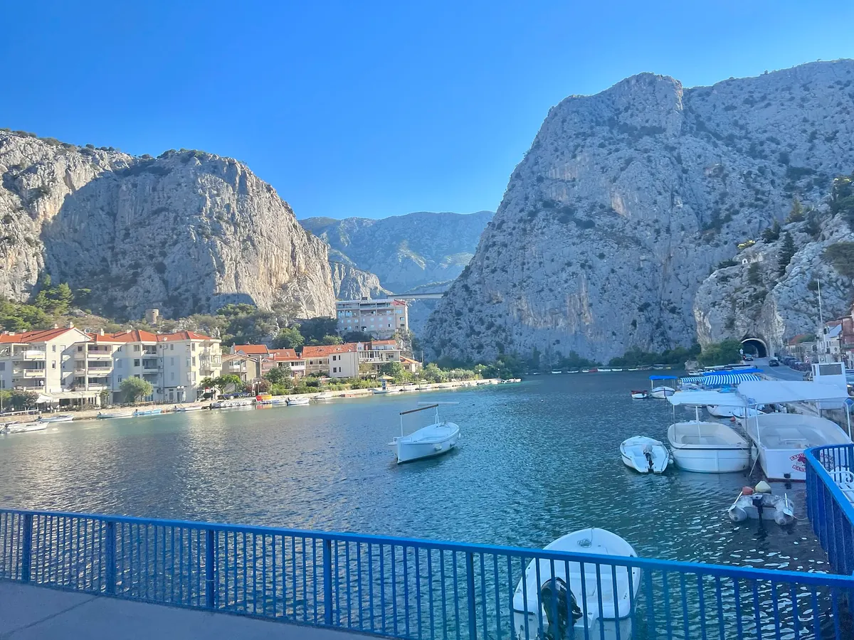 Swimmers and boats along the Omiš waterfront under summer sun