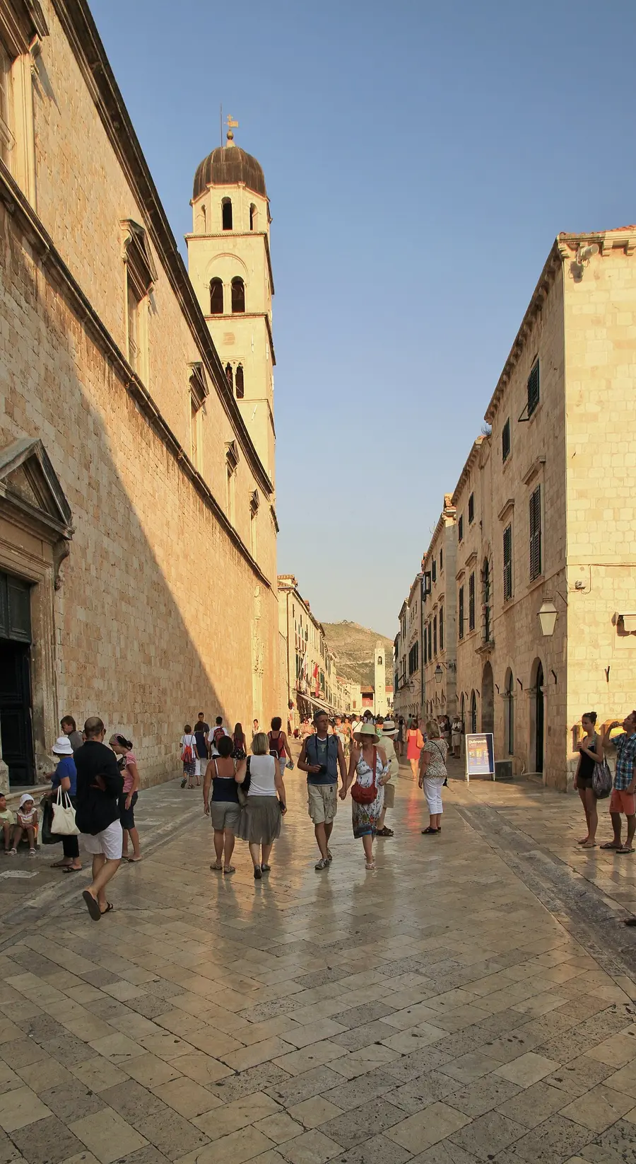 The polished limestone Stradun main street of Dubrovnik lined with shuttered stone buildings and cafes