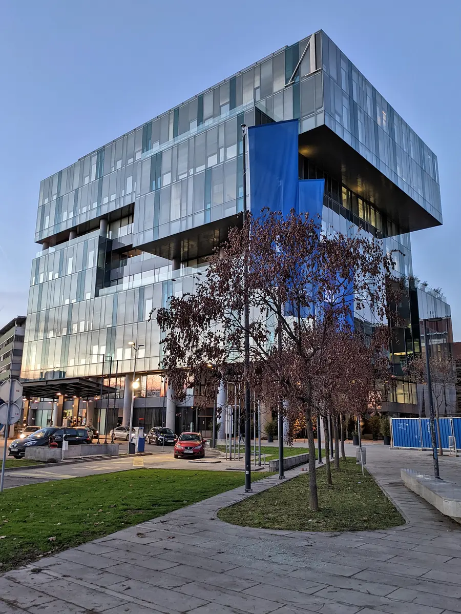 A modern glass office building in Zagreb at dusk