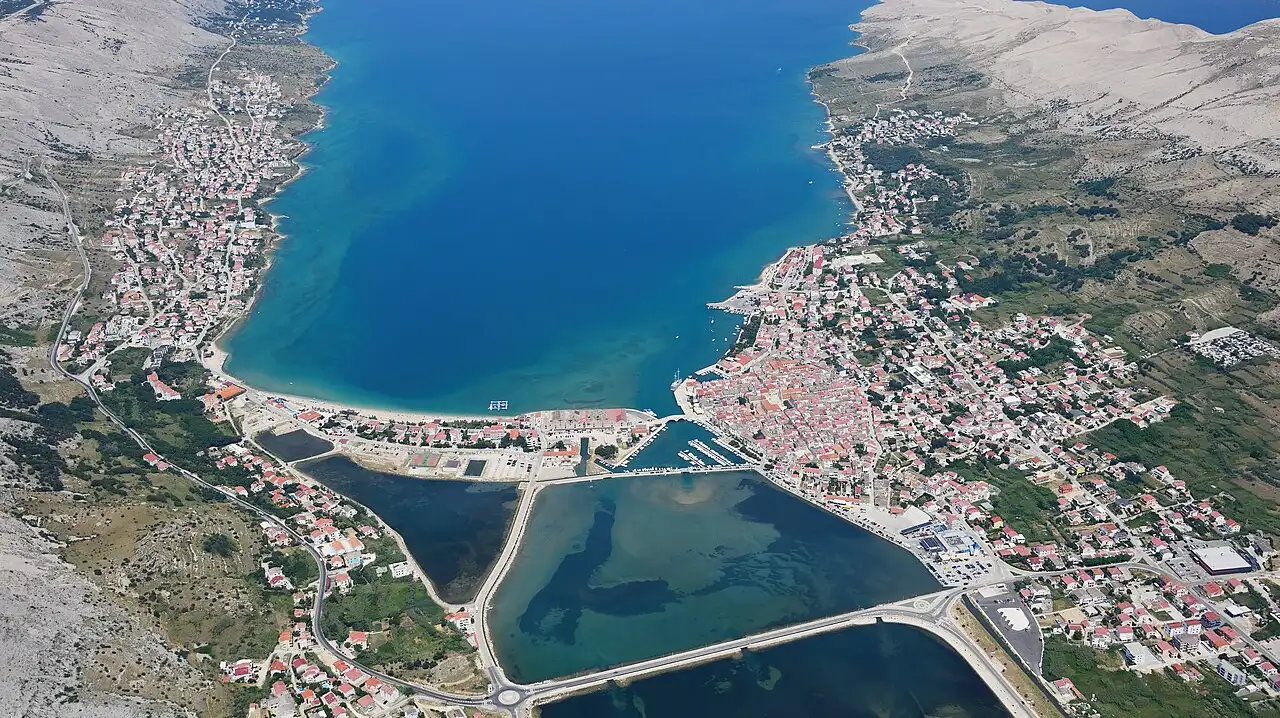Aerial view of the town of Pag on its bay, with the bare pale hills of the island behind
