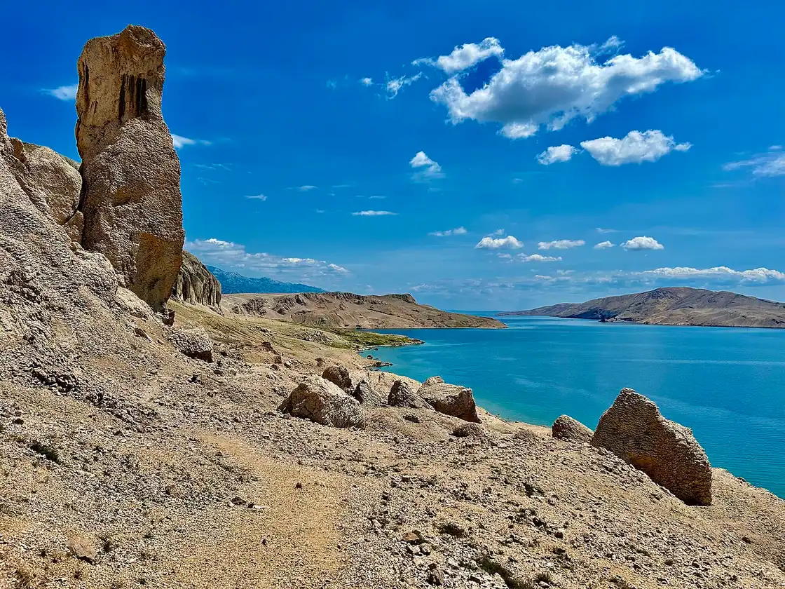 The bare grey limestone landscape of Pag with dry-stone walls and no trees, on the trail near Metajna