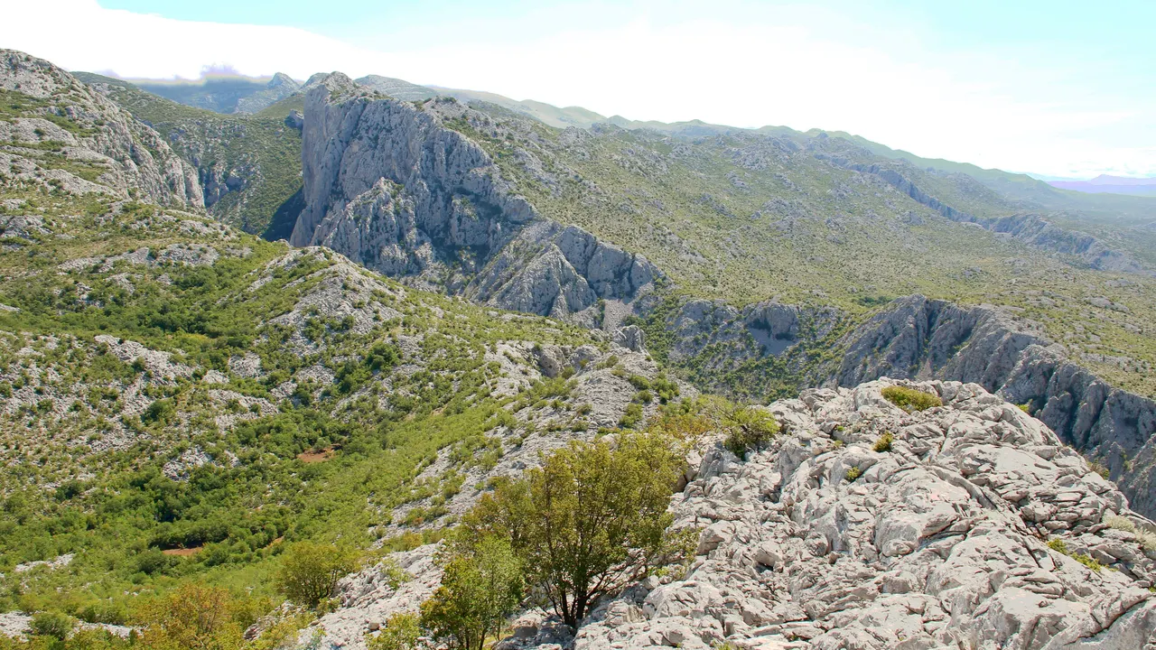 A high viewpoint over the bare, jagged karst peaks and green ridgelines of the Velebit mountains inside Paklenica National Park