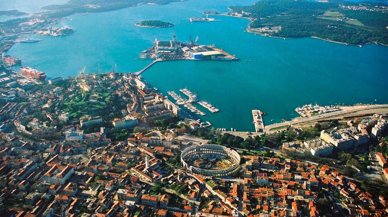 Aerial view of Pula, Istria, with the Roman Arena among the terracotta rooftops and the harbour behind