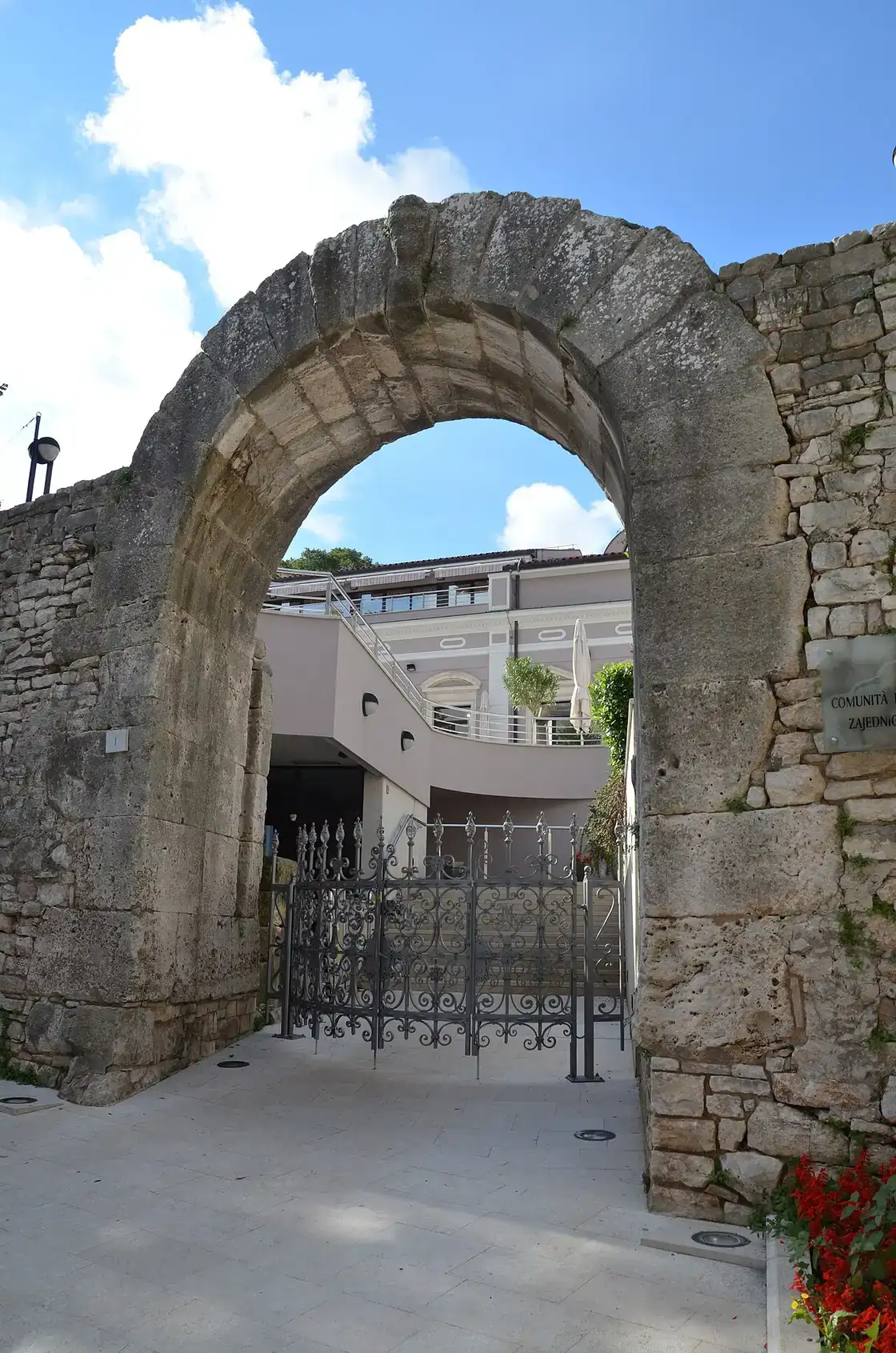 The weathered Roman Gate of Hercules, the oldest surviving monument in Pula, set into the old stone wall