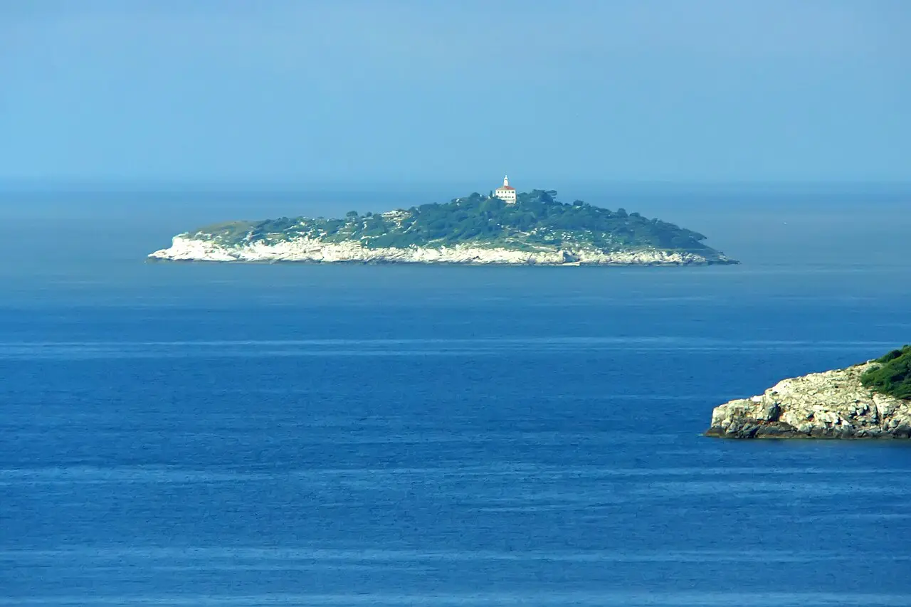 The lighthouse and wooded shore of Sveti Andrija (Red Island) in the Rovinj archipelago