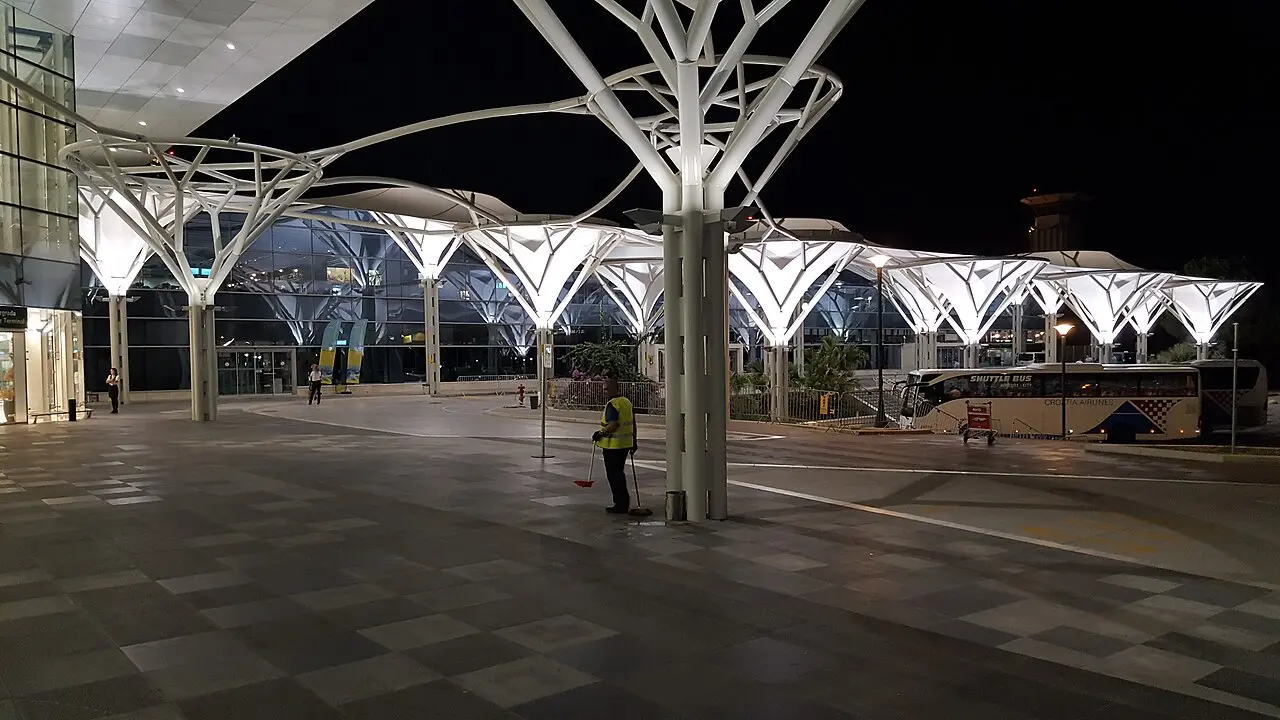A Croatia Airlines shuttle coach waiting outside the lit Split Airport terminal at night