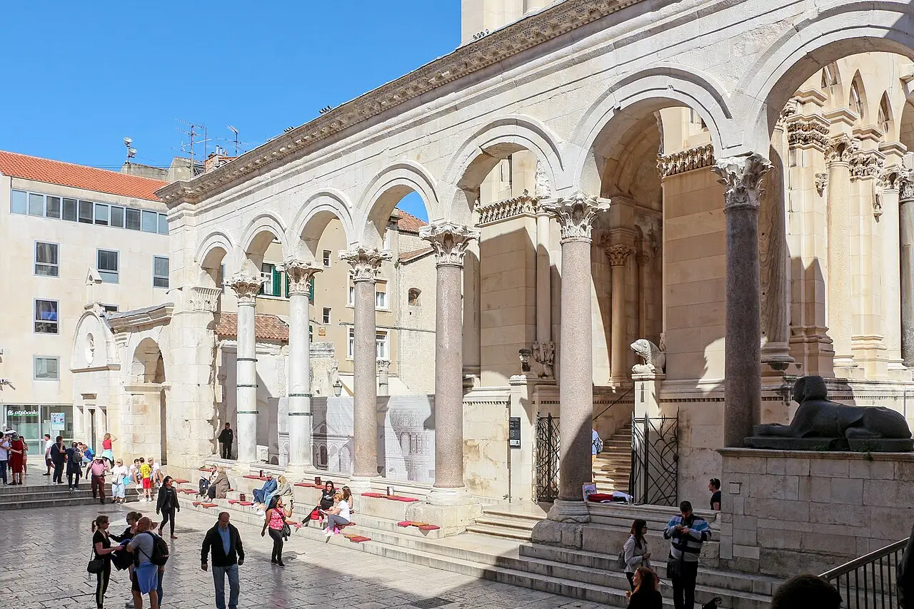 The Peristyle courtyard of Diocletian's Palace in Split, ringed by Roman columns, where evening bars set out cushions on the steps
