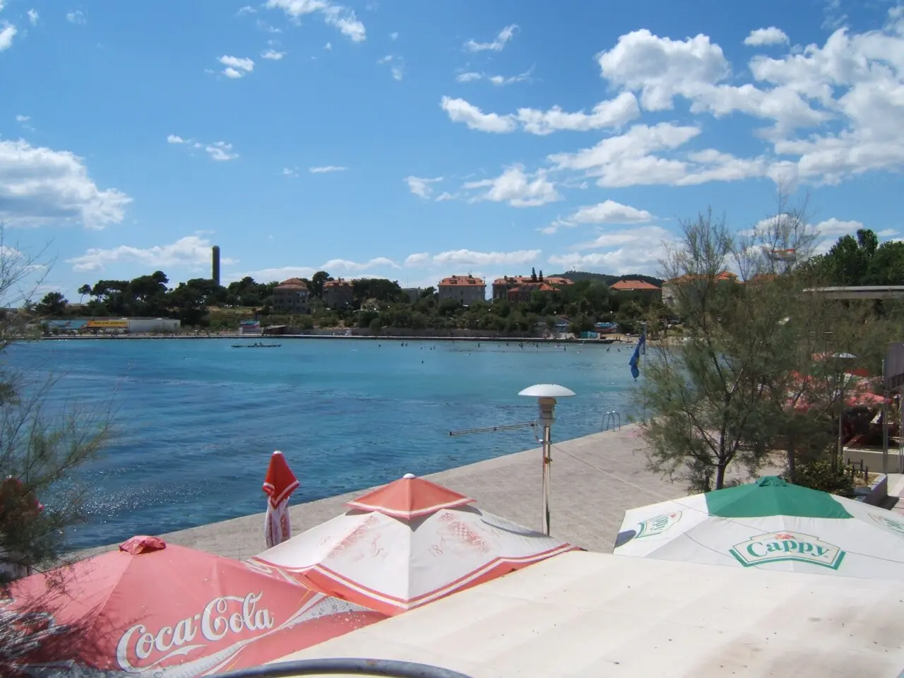Bačvice beach in Split with sand, umbrellas and the bay opening toward the harbour
