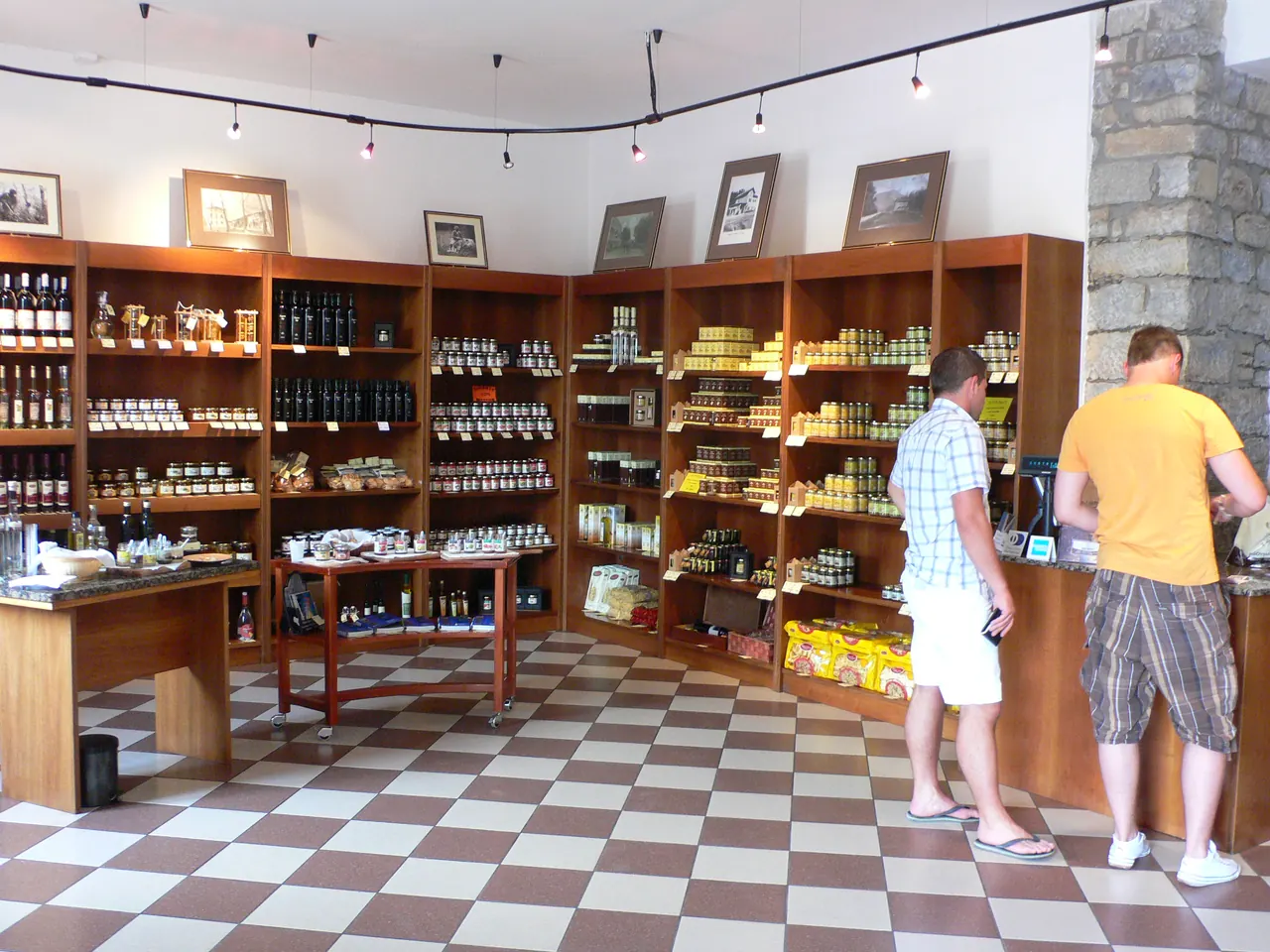 Shelves of truffle products, oils and wines inside a truffle shop in Istria with two customers at the counter