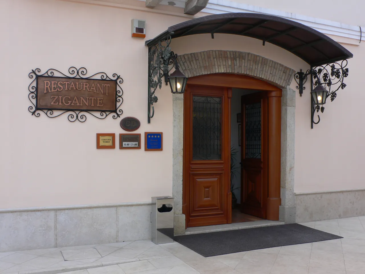 The wrought-iron sign and arched doorway of Restaurant Zigante in Livade, Istria