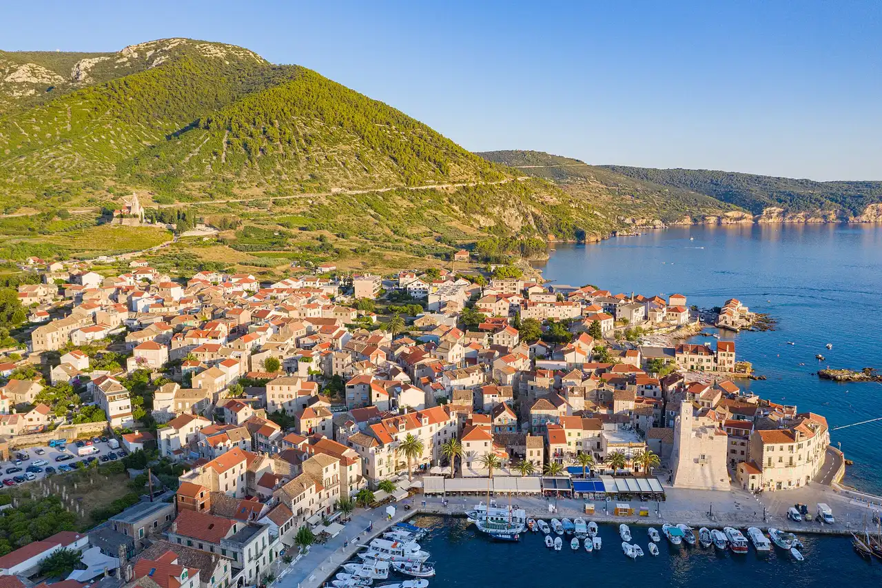 Komiža harbour on Vis with the stone church of St Nicholas on the hill above the fishing boats
