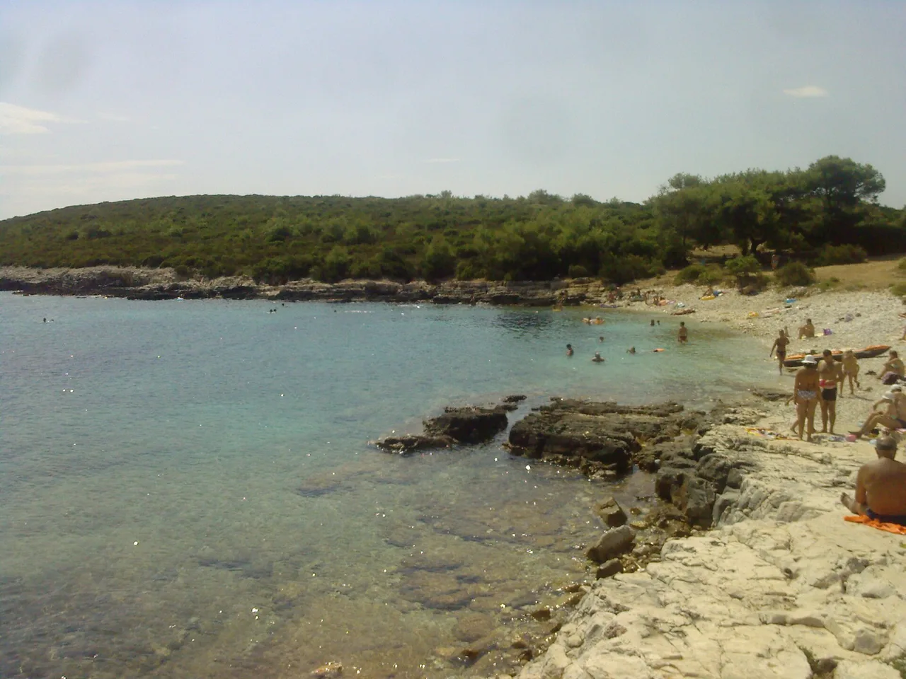 Srebrna beach on Vis, a curve of white pebbles backed by pines meeting clear blue-green water