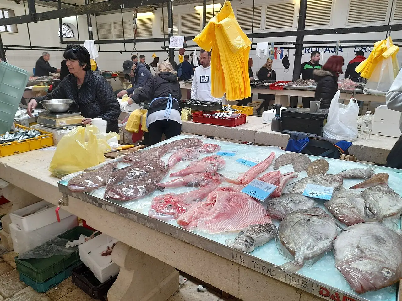 Monkfish tails and flat fish laid out with price cards on a Split fish market slab