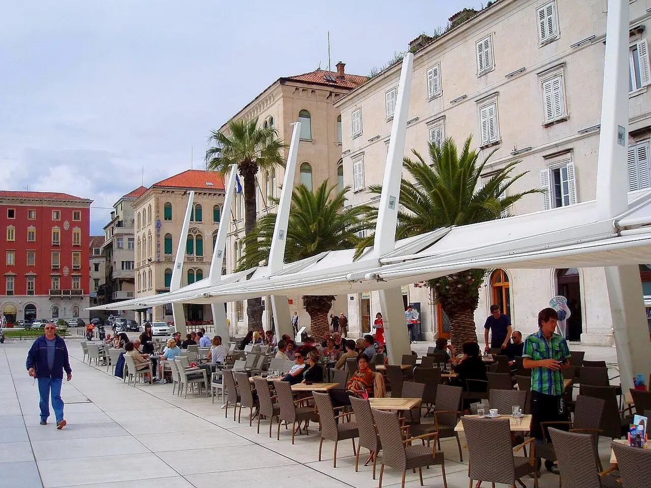Cafe tables and white sunshades along the Riva waterfront promenade in Split