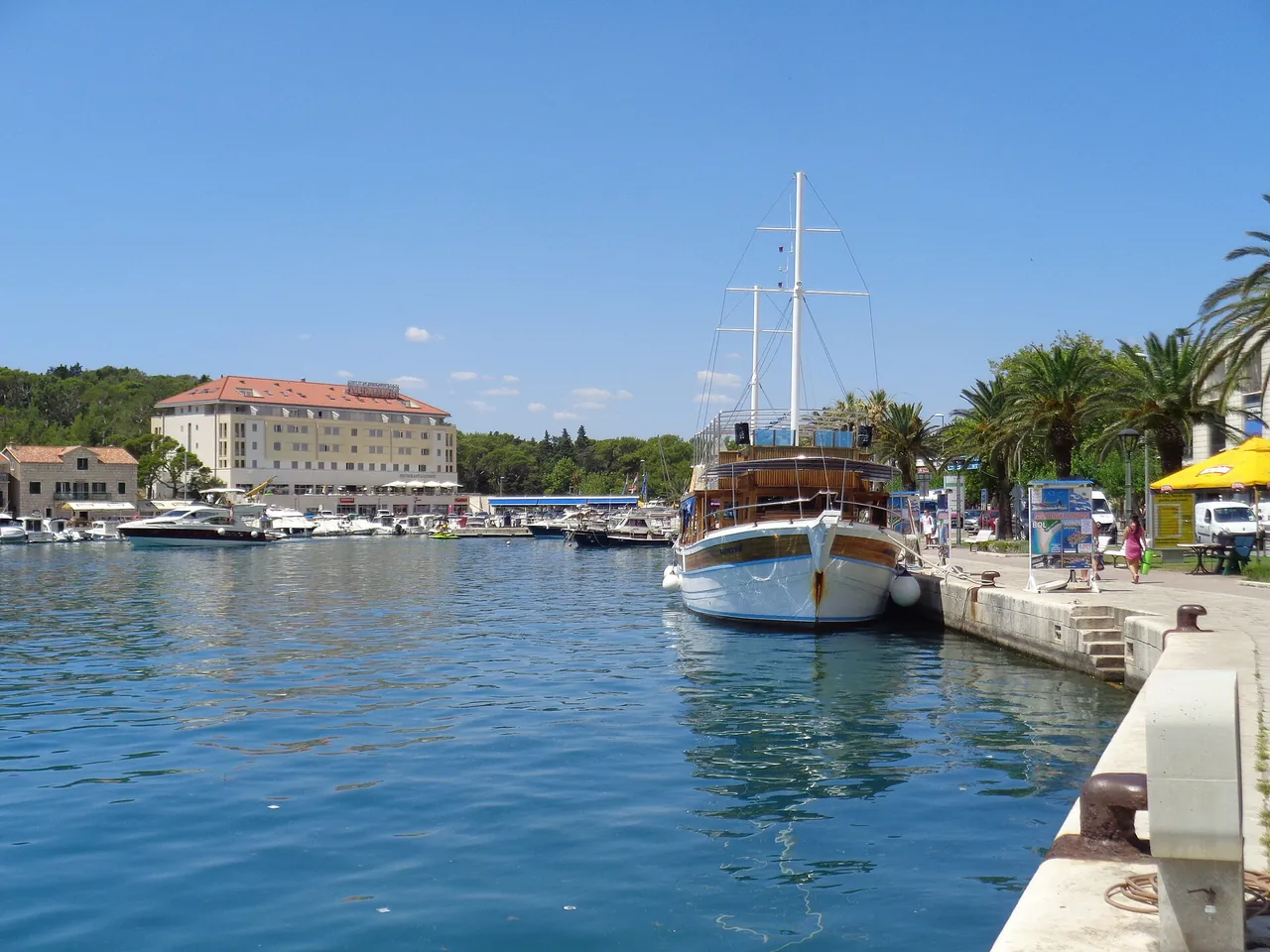 Fishing boats moored along the Makarska harbour quay with town buildings behind