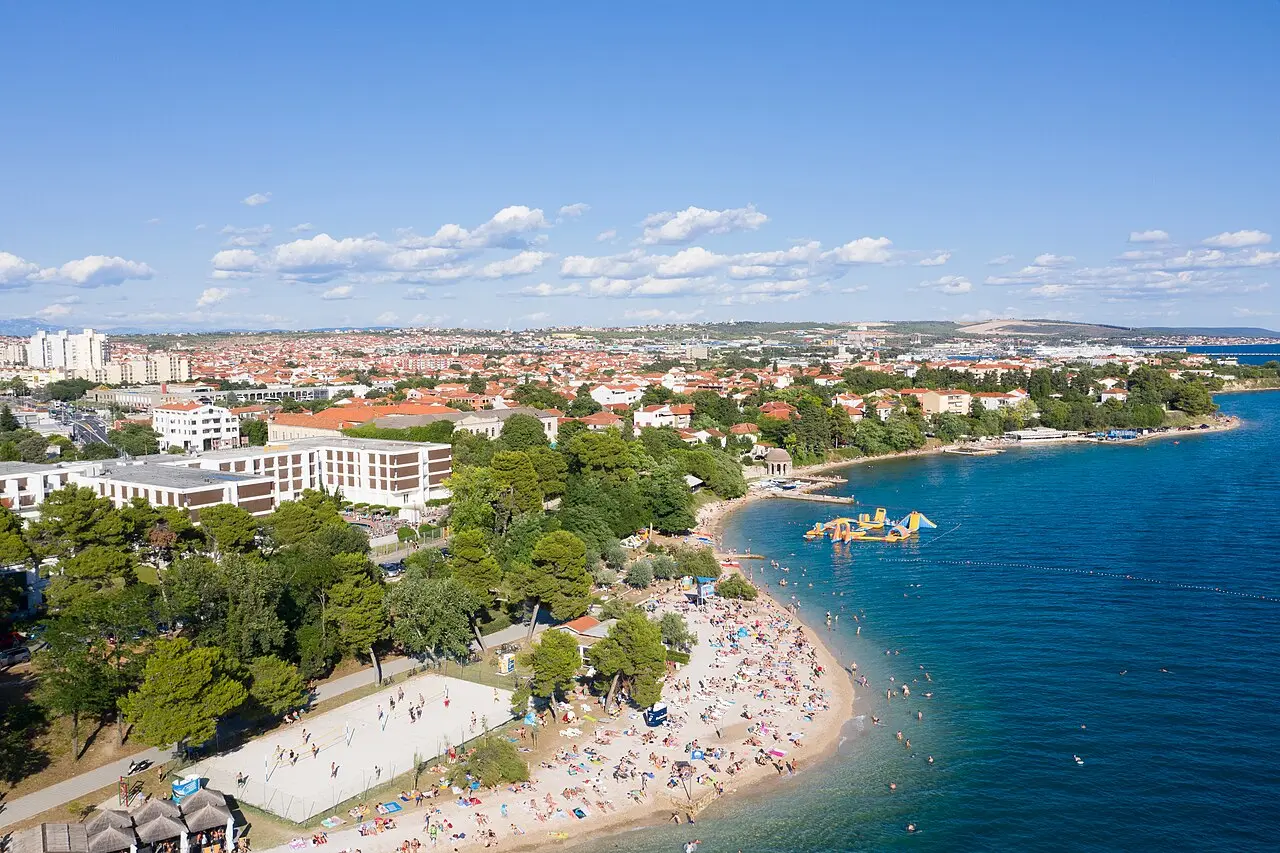 Kolovare city beach along the Adriatic coast of Zadar with pine trees and clear water