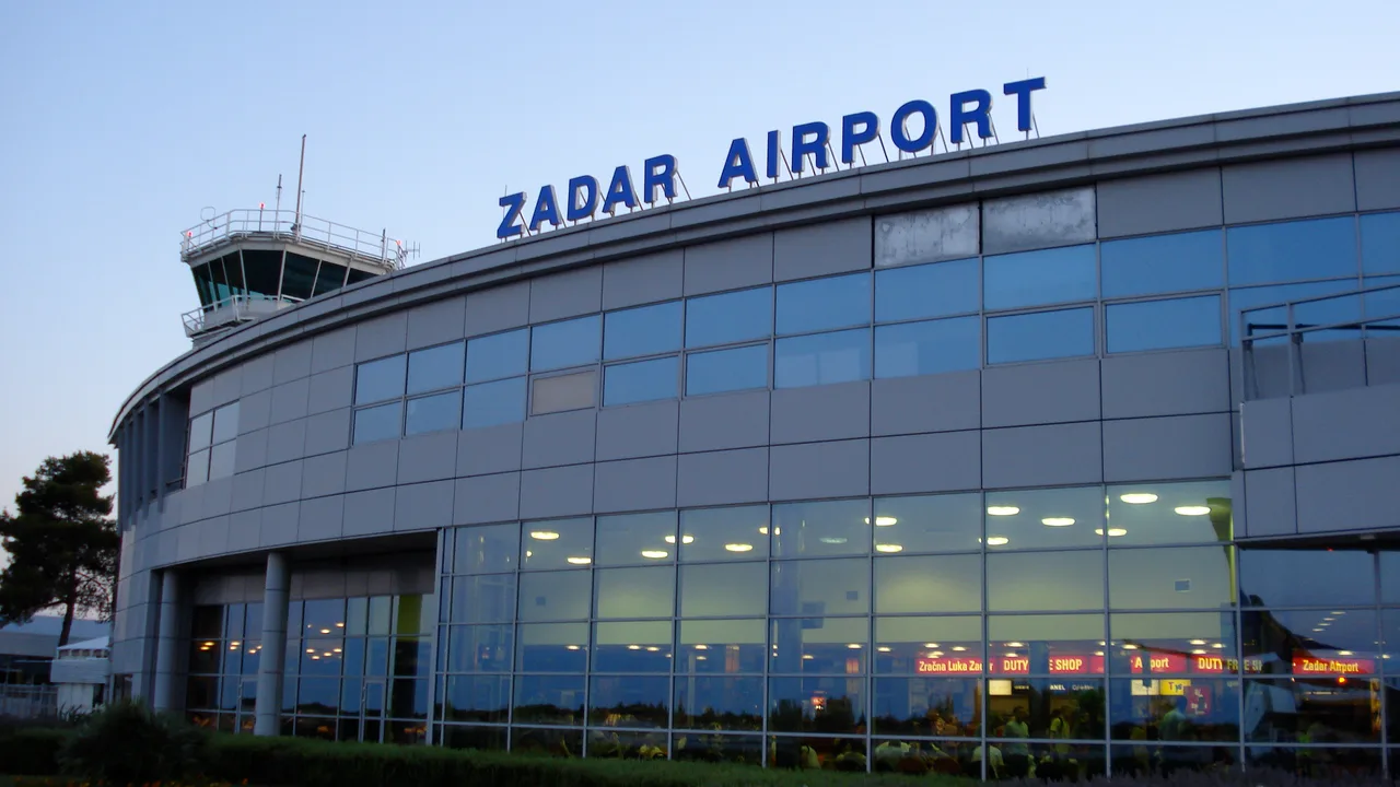 The terminal building at Zadar Airport with cars parked in front