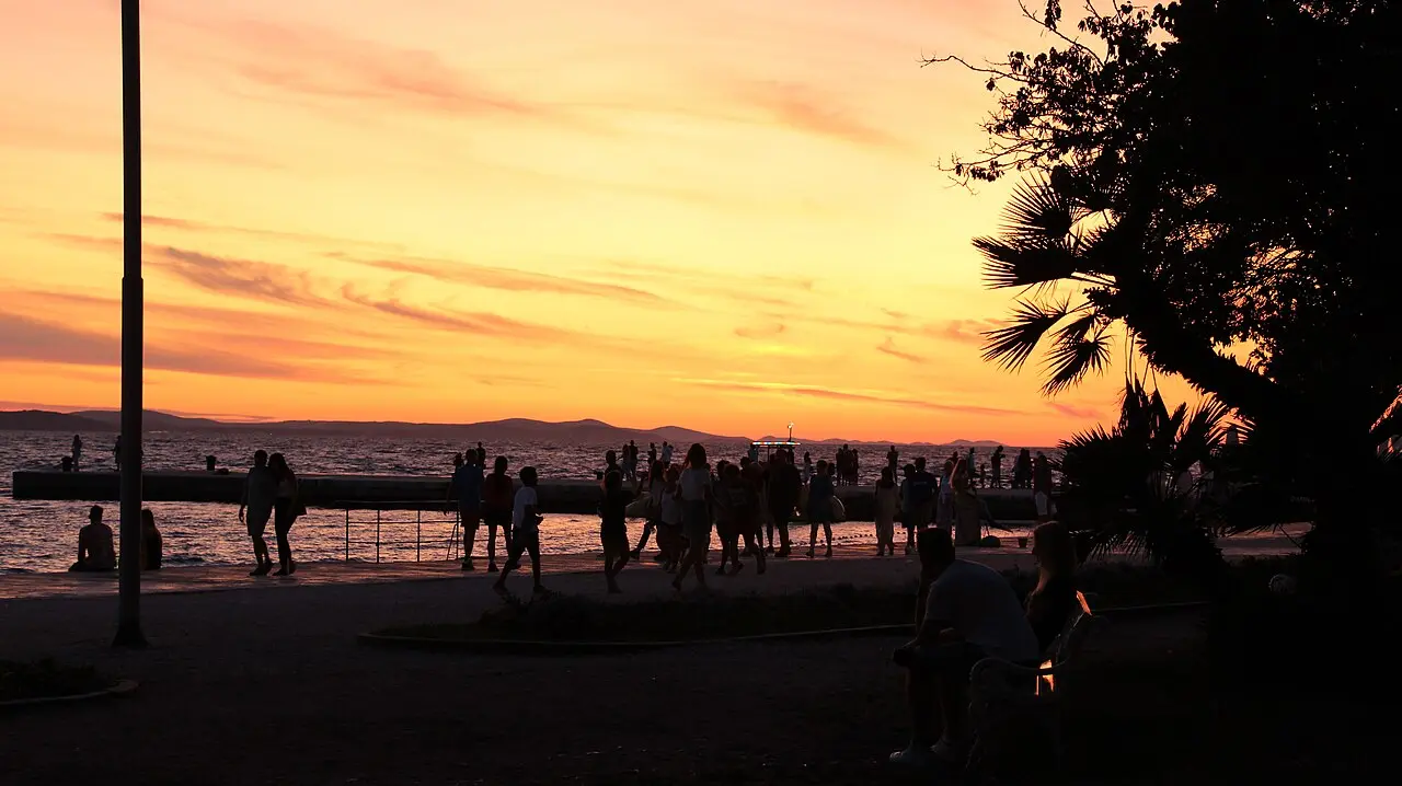 People watching the sunset from the Zadar waterfront, with the sea and islands on the horizon