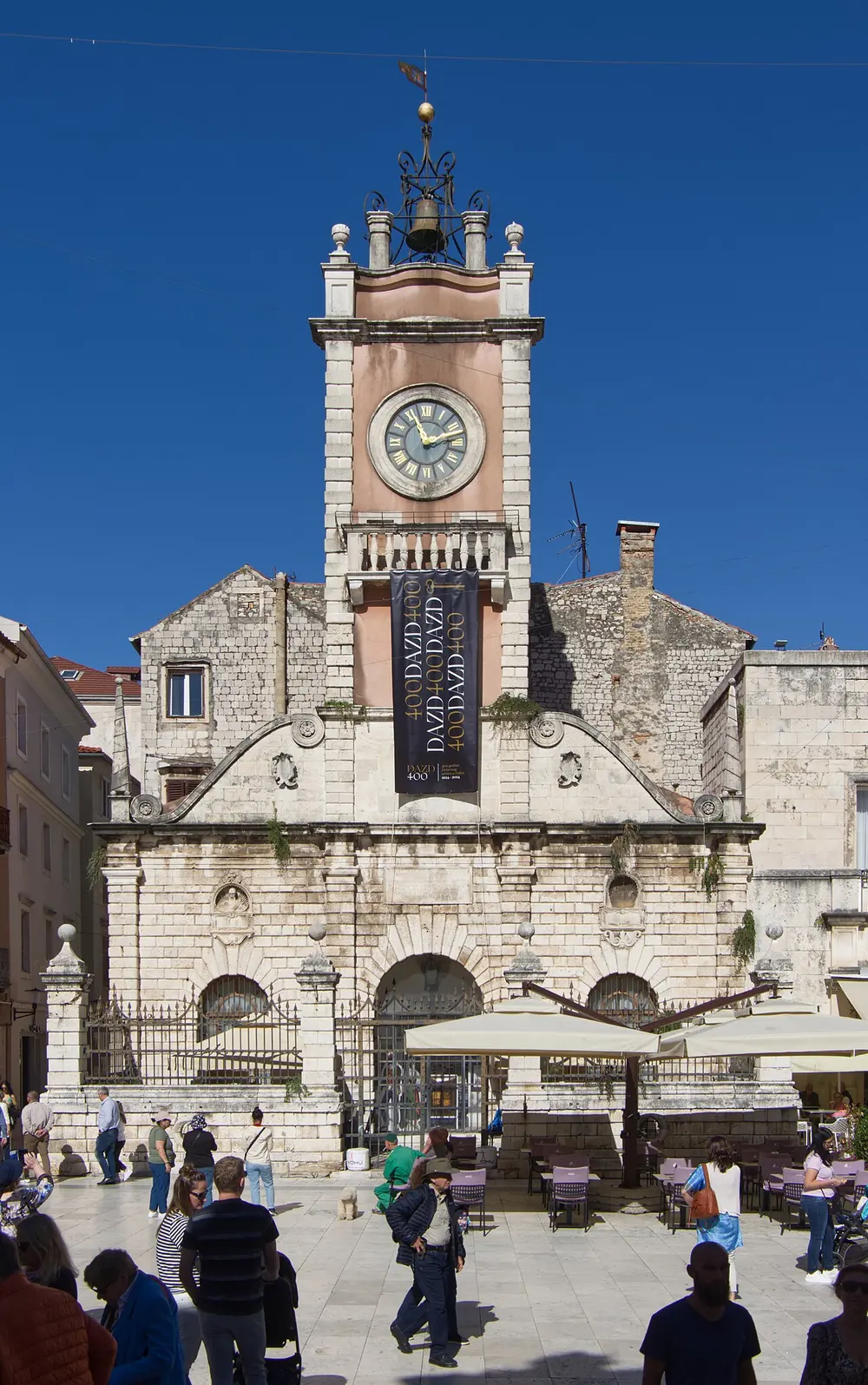 A narrow stone-paved lane in Zadar old town between tall shuttered buildings