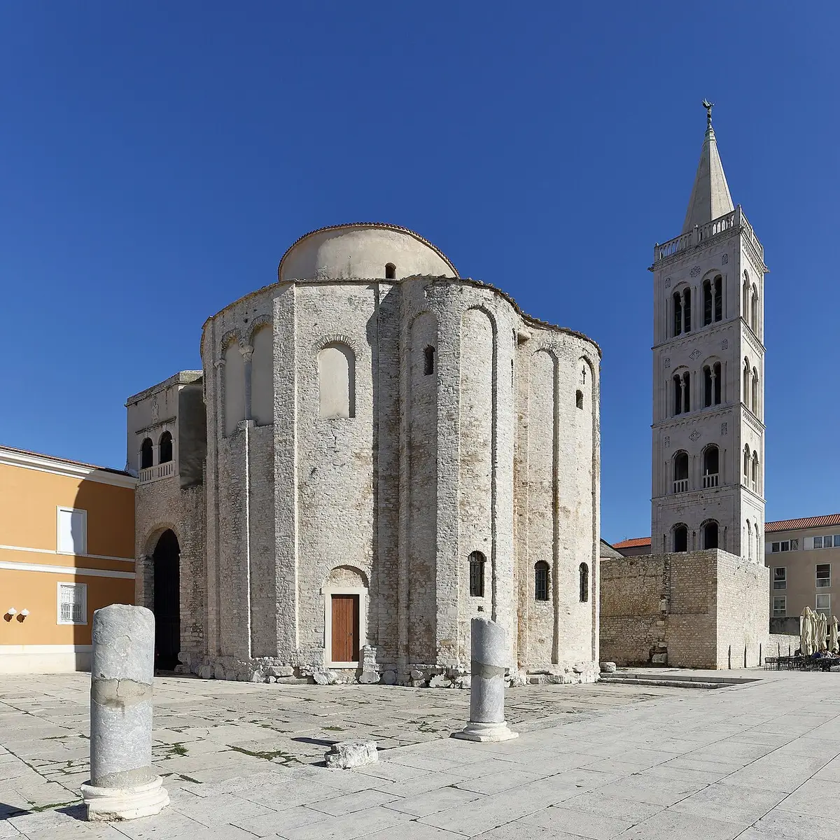 The tall round pre-Romanesque Church of St Donatus in Zadar with the cathedral bell tower behind