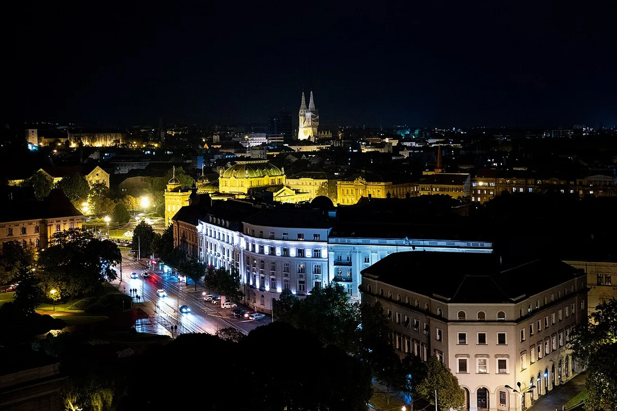 The Upper Town of Zagreb lit up after dark, its rooftops and church spires visible above the old streets