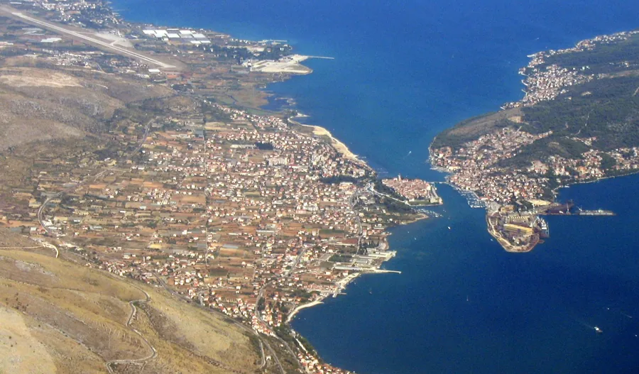 Aerial view of Trogir island old town, the channel and the runway of Split Airport behind