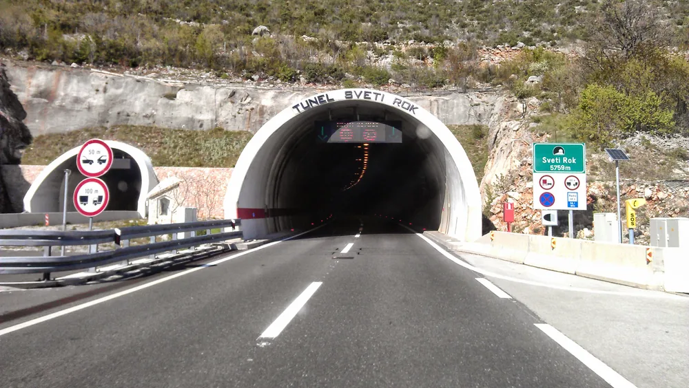 The portal of the Sveti Rok tunnel on the A1 motorway with its length shown on the roadside sign